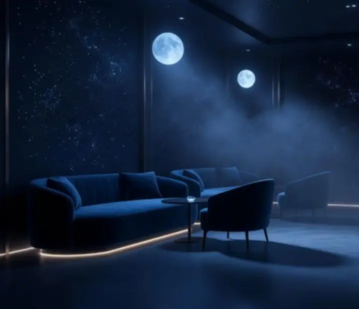 Lounge tér mélykék, moonlight fényekkel és elegáns bútorelrendezéssel.